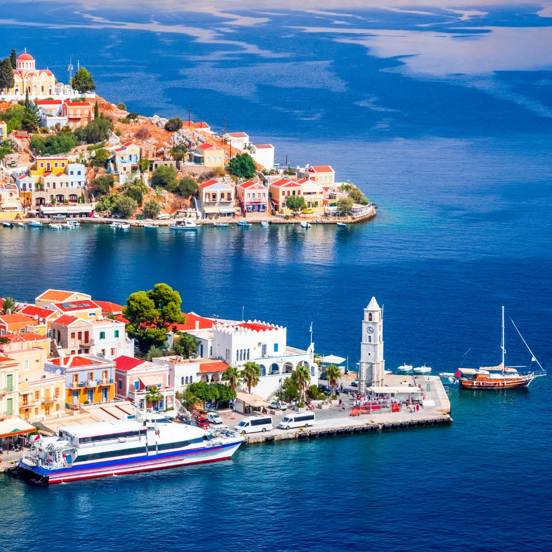 Γραφικό λιμάνι με βάρκες σε ελληνικό νησί, ο ιδανικός προορισμός για καλοκαιρινές ομαδικές διακοπές.
