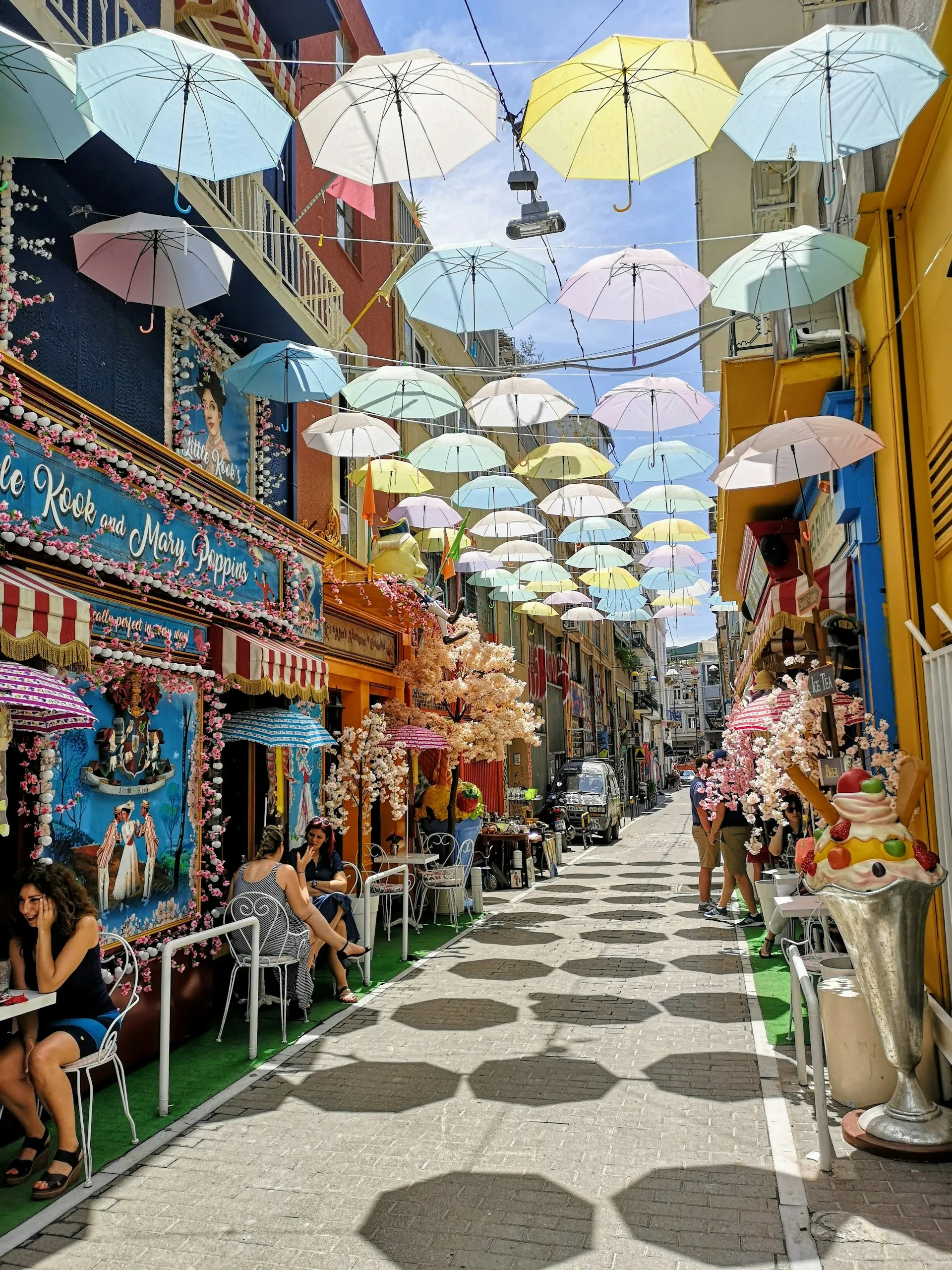Πολύχρωμες ομπρέλες αιωρούνται σε άδειο πλακόστρωτο του Ψυρρή, αναδεικνύοντας την ομορφιά της Αθήνας σε VIP tour.