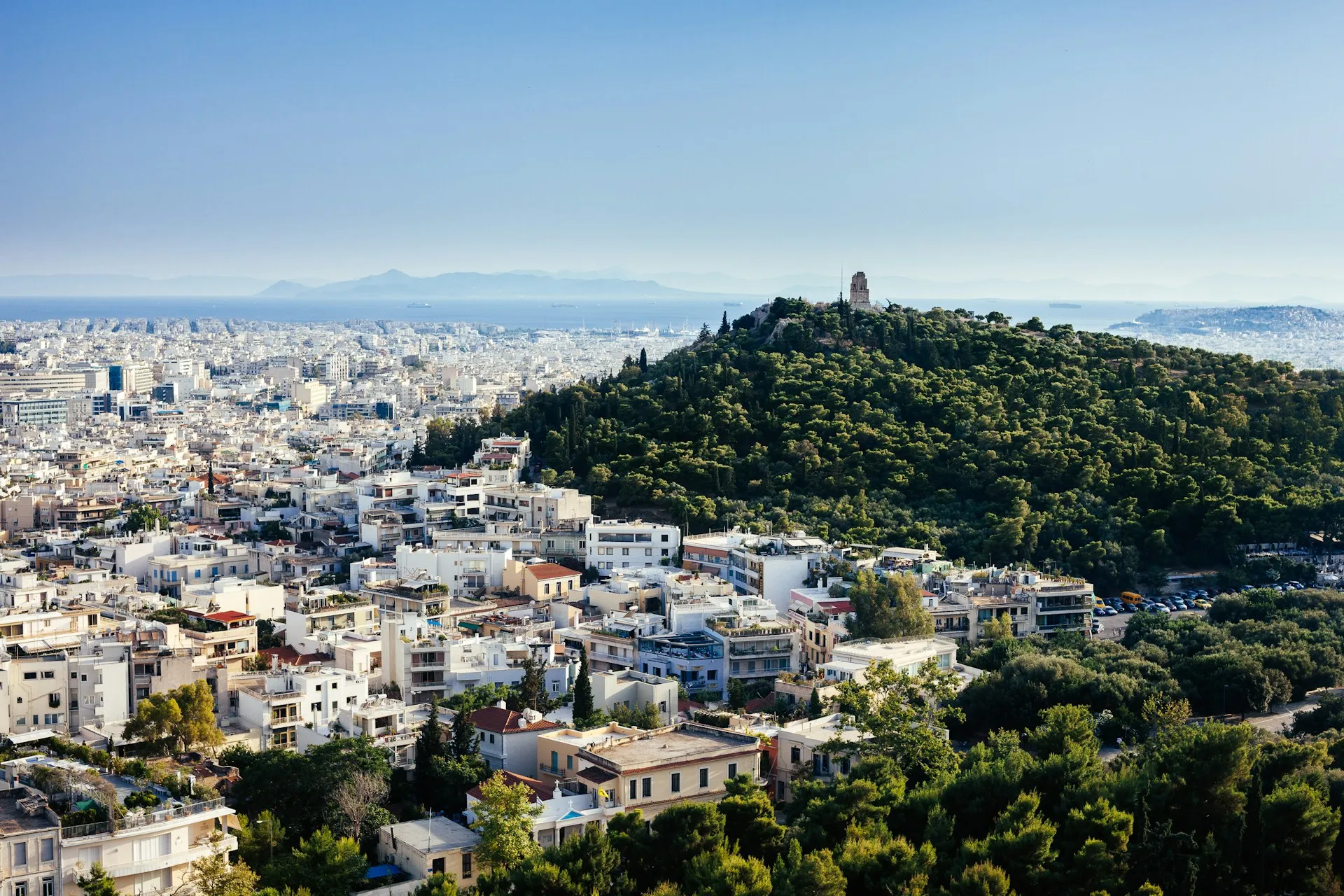 Πανοραμική θέα του αστικού ιστού της Αθήνας και καταπράσινου λόφου για μετακινήσεις συνεδρίων